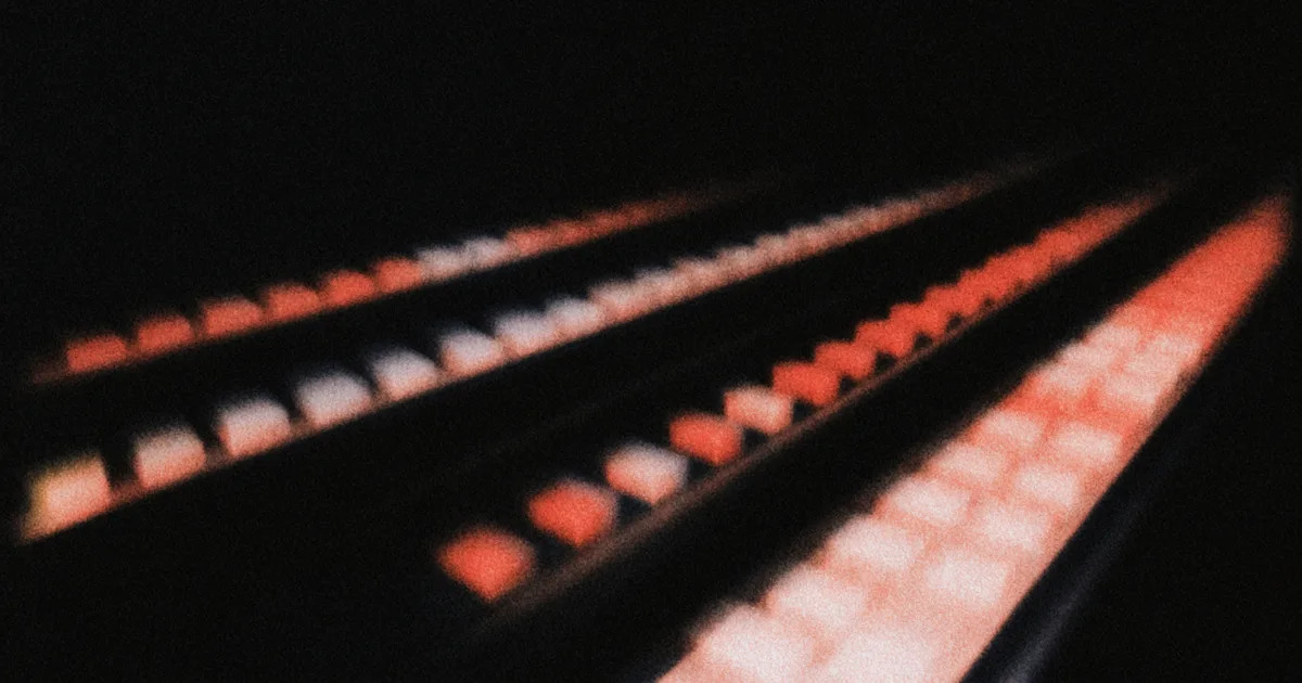 Four factory belts in the dark, each with a row of vermilion and white items.